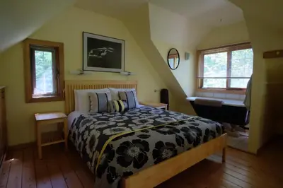 a bedroom with a bed and a bathroom with a piano at Wedgwood Manor and Glamping Retreat in Crawford Bay