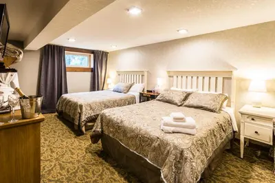 a hotel room with two beds with towels on them at Rustlers Lodge in Sundre