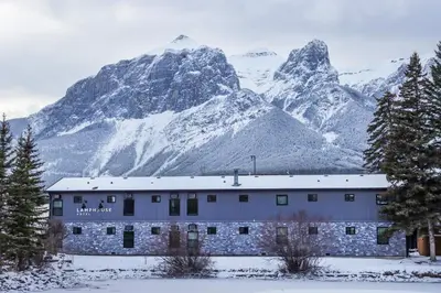 a building in front of a snow covered mountain at Lamphouse By Basecamp in Canmore