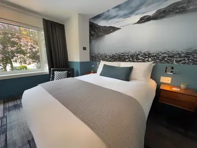 a hotel room with a bed and a painting on the wall at Artisan Suites on Bowen in Bowen Island