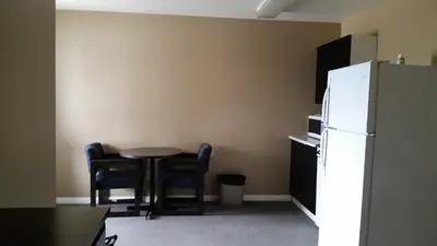 a kitchen with a table and chairs and a refrigerator at Chinook Country Inn in Sundre
