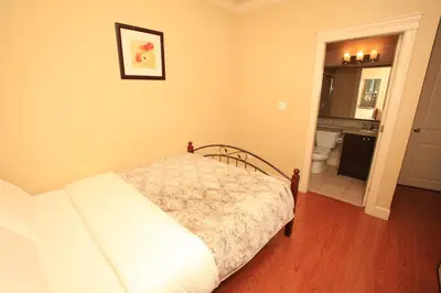 a bedroom with a bed and a bathroom at Imperial House in Burnaby