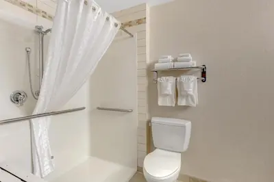 a white bathroom with a shower and a toilet at Best Western Wainwright Inn & Suites in Wainwright