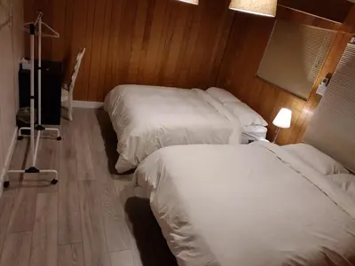 two beds in a hotel room with white sheets at City Gardens Suites B&B in North Vancouver