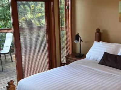 a bedroom with a bed and a window with a balcony at Sunshine Coast Resort in Madeira Park