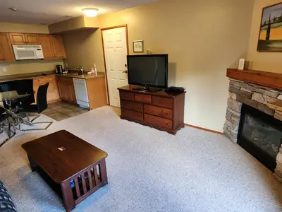 a living room with a television and a fireplace at Sunshine Coast Resort in Madeira Park