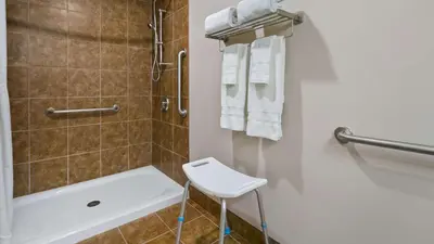 a bathroom with a shower and a toilet and a sink at Best Western Plus Chateau Inn Sylvan Lake in Sylvan Lake