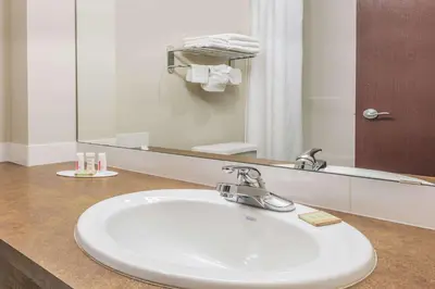 a bathroom with a sink and a large mirror at Super 8 by Wyndham Innisfail in Innisfail
