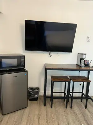 a desk with a microwave and a television on a wall at The Spot in Nanaimo