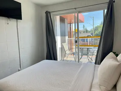 a bedroom with a bed and a door to a patio at The Spot in Nanaimo