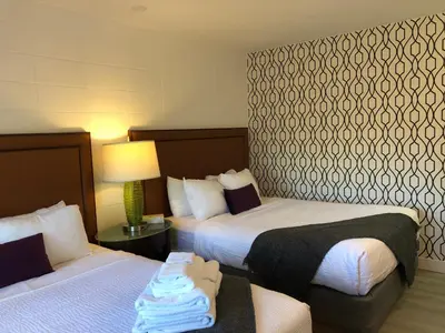 a hotel room with two beds and a lamp at The Spot in Nanaimo