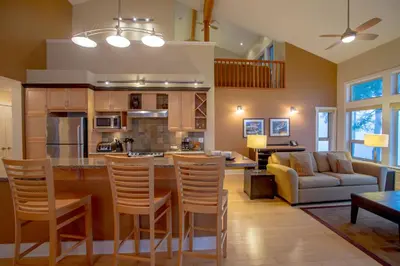 a kitchen and living room with a couch and a table at Painted Boat Resort Spa and Marina in Madeira Park