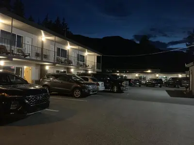 a group of cars parked in a parking lot at night at City Centre Motel older building in Hope