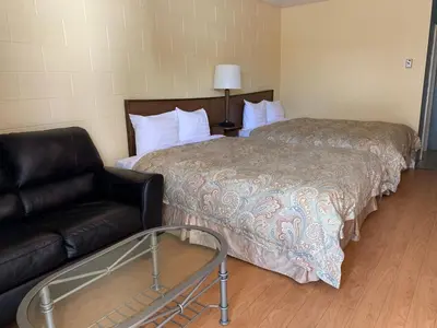 a hotel room with a bed and a couch at City Centre Motel older building in Hope