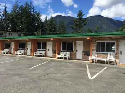 a building with white chairs in a parking lot at City Centre Motel older building in Hope