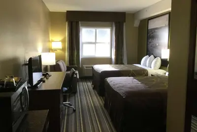 a hotel room with two beds and a television at Super 8 by Wyndham Hardisty in Hardisty