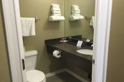 a bathroom with a sink and a toilet and a mirror at Super 8 by Wyndham Hardisty in Hardisty