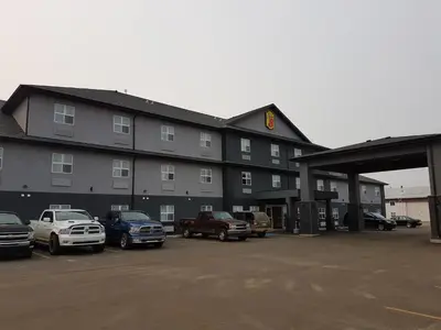 a large building with cars parked in a parking lot at Super 8 by Wyndham Hardisty in Hardisty