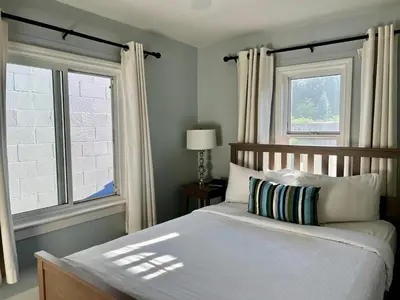 a bedroom with a bed and two windows at Buccaneer Inn in Nanaimo