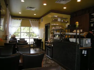 a restaurant with chairs and a person sitting at a counter at Oceanside Village Resort in Parksville