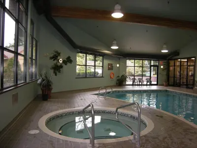 an indoor pool with a hot tub in a building at Oceanside Village Resort in Parksville