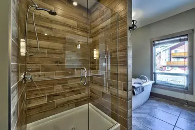 a bathroom with a shower with a tub and a sink at 17 Village Walk Sun Peaks BC in Sun Peaks