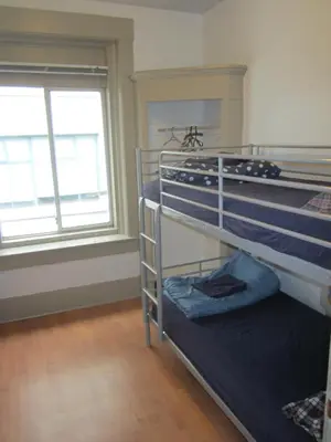 a bedroom with two bunk beds and two windows at St Clair Hostel in Vancouver