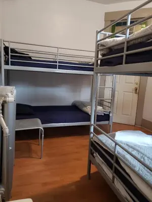 a room with three bunk beds in a hostel at St Clair Hostel in Vancouver
