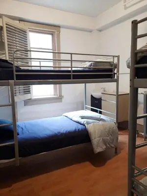 a bedroom with two bunk beds and a window at St Clair Hostel in Vancouver