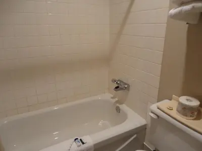 a bathroom with a white tub and a toilet at Falcon Resort in Osoyoos