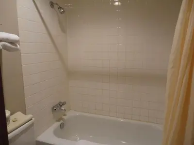 a bathroom with a white tub and a toilet at Falcon Resort in Osoyoos