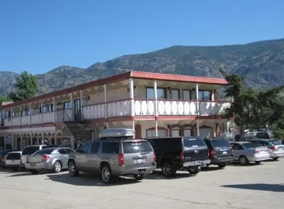 a parking lot with cars parked in front of a building at Falcon Resort in Osoyoos