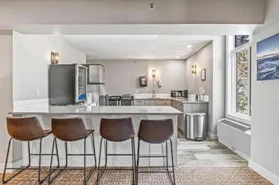 a kitchen with a bar with stools in it at Basecamp Lodge Canmore in Canmore