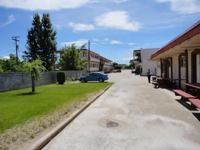 a street in a small town with a blue car at Spanish Fiesta Resort in Osoyoos
