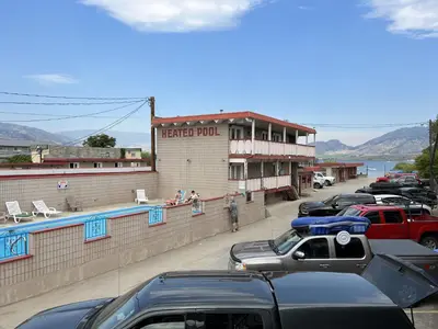 a row of cars parked in front of a hotel room at Spanish Fiesta Resort in Osoyoos