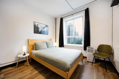 a bedroom with a bed and a window at Samesun Vancouver in Vancouver