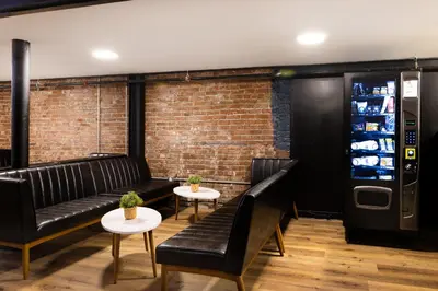 a bar with black leather furniture and a vending machine at Samesun Vancouver in Vancouver