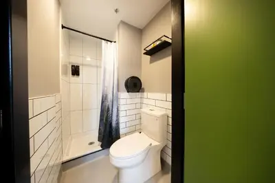 a bathroom with a white toilet and a shower at Samesun Vancouver in Vancouver