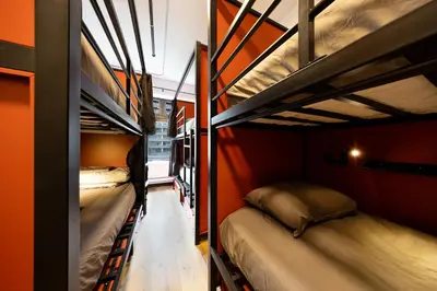 two bunk beds are in a room with red walls at Samesun Vancouver in Vancouver