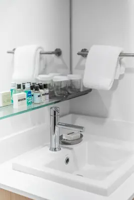 a white bathroom sink with a chrome faucet at Gage Suites at UBC in Vancouver