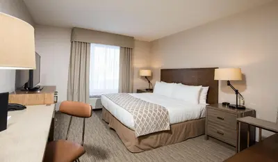 a hotel room with a bed and a desk at Pomeroy Inn & Suites Prince George in Prince George
