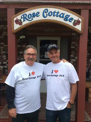 two men in white tshirts standing in front of a store at Rose Cottage Bed & Breakfast in Valemount
