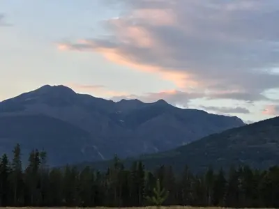 a view of a mountain range with a sunset at Rose Cottage Bed & Breakfast in Valemount
