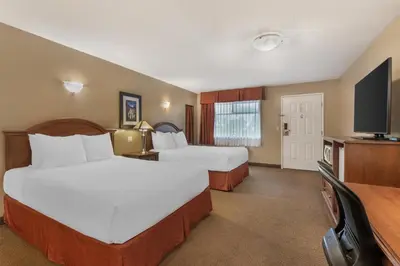 a hotel room with two beds and a flat screen tv at Best Western Sicamous Inn in Sicamous