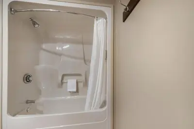 a bathroom with a bath tub with a shower curtain at Best Western Sicamous Inn in Sicamous