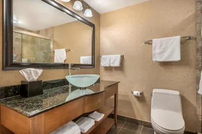 a bathroom with a sink and a toilet and a mirror at Best Western Sicamous Inn in Sicamous