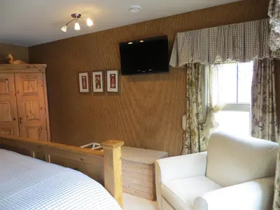 a bedroom with a bed and a tv on the wall at Buffaloberry Bed & Breakfast in Banff