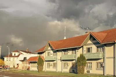 a group of buildings with a fire in the background at Stork Nest Inn in Smithers