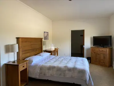 a bedroom with a bed and a flat screen tv at Stork Nest Inn in Smithers
