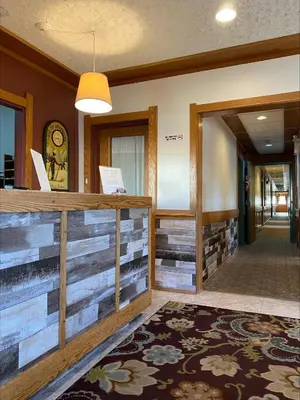 a lobby with a reception desk and a hallway at Stork Nest Inn in Smithers